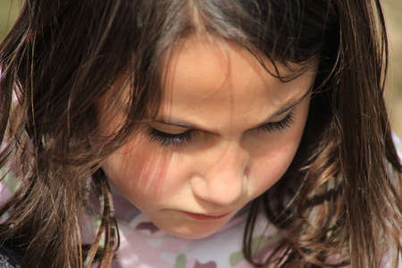 Close-up of a girl's face looking at the groundの写真素材