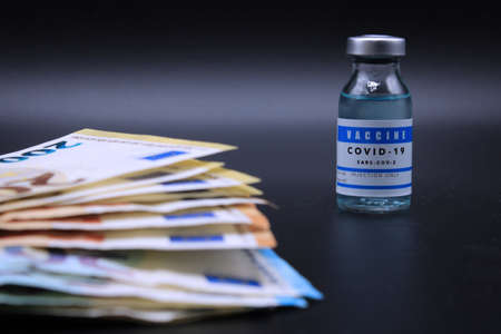 Euro banknotes with a vial of bottom vaccineの写真素材