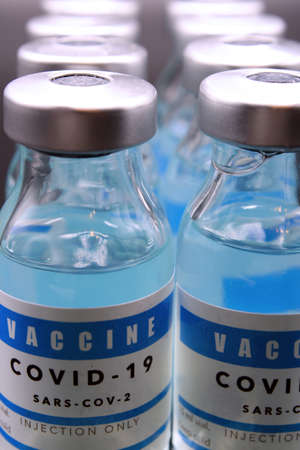 Covid-19 vaccine vials lined up on a black backgroundの写真素材