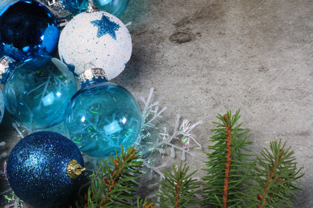 Blue christmas balls on a table with fir branches and snowflakesの写真素材