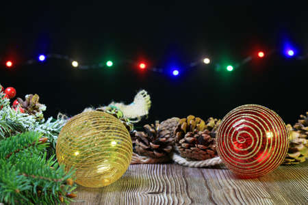 Christmas balls on a table with fir branches and pine conesの写真素材