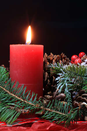Christmas scene with fir branches, pine cones and a candleの写真素材