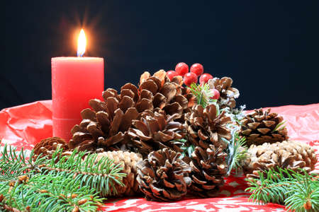 Christmas scene with fir branches, pine cones and a candleの写真素材