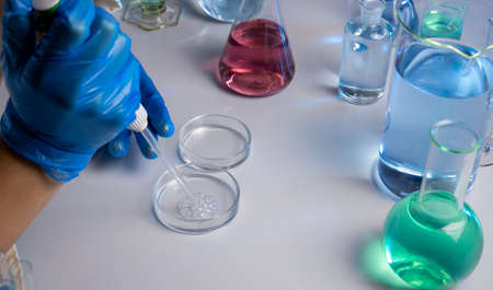 Hand of a scientist taking samples with a pipette