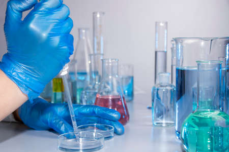 Hand of a scientist taking samples with a pipette