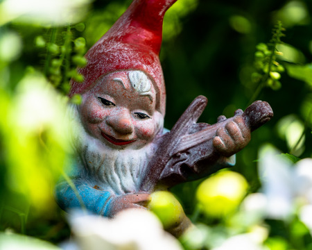 Smurf or gnome in a garden with a beautiful pose.