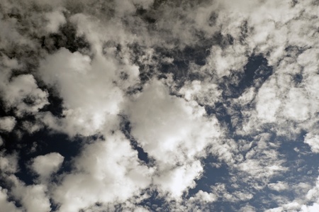 Blue sky with white scattered cloudsの写真素材