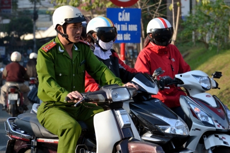 Dalat, Vietnam - February 10, 2012: Policeman on motorcycle on February 10, 2012 in Dalat, Vietnam. Musicians Vo Minh Tri and Tran Vu Anh Binh were sentenced to prison on October 30, 2012 on charges of spreading propaganda against the state.のeditorial素材