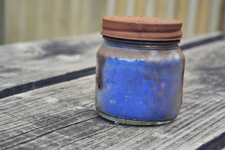 Small glass bottle full of blue paintの写真素材