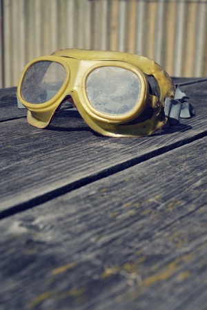 Filtered picture of a vintage safety glasses on a wooden tableの写真素材