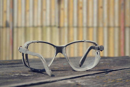 Filtered picture of a vintage safety glasses on a wooden tableの写真素材
