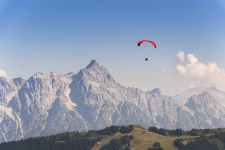 Paraglider flyes over mountains near Saalbach-Hinterglemm  in Alps, Austriaの写真素材