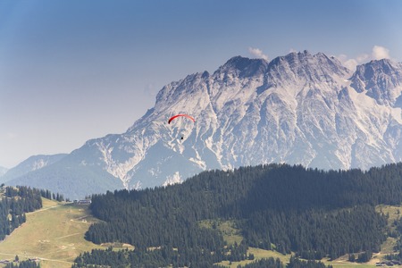 Paraglider flyes over mountains near Saalbach-Hinterglemm  in Alps, Austriaの写真素材