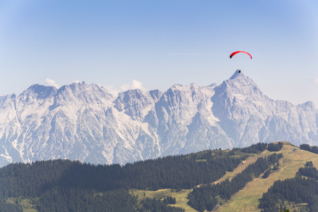 Paraglider flyes over mountains near Saalbach-Hinterglemm  in Alps, Austriaの写真素材