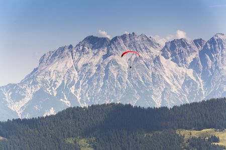 Paraglider flyes over mountains near Saalbach-Hinterglemm  in Alps, Austriaの写真素材