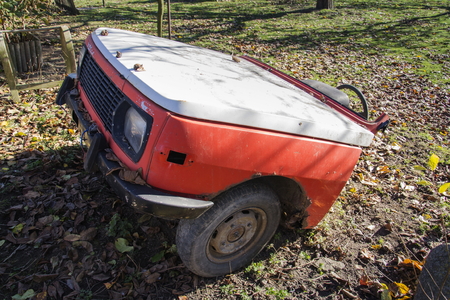 Rusty vintage car cut in half on a sunny day in autumn gardenの写真素材
