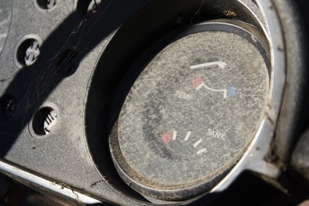 Rusty fuel gauge on vintage car control panel on sunny dayの写真素材
