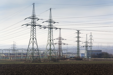 Distribution power station with electricity pylons and dramatic cloudy sky backgroundの写真素材