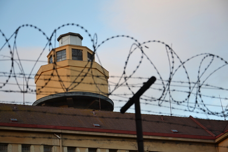 Barbed wire fence layed around prison wallsの写真素材