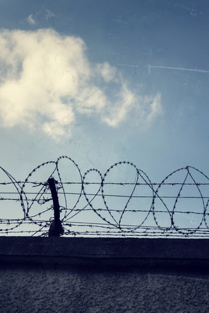 Filtered vintage picture of barbed wire prison fence detailの写真素材