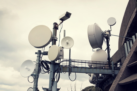 Filtered security camera with transmitters and aerials on telecommunication towerの写真素材