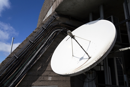 Satellite dish on telecommunication tower on sunny dayの写真素材