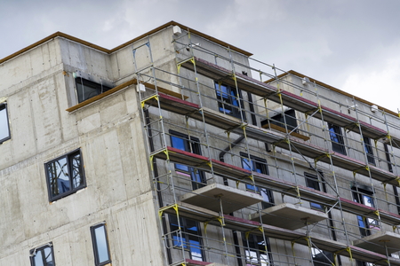 Horizontal photo of house apartment construction site with scaffoldingの写真素材