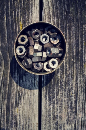 Nuts in a tin can on wooden board backgroundの写真素材