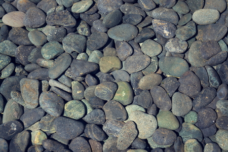 Grey stone pebbles under water lake bed backgroundの写真素材
