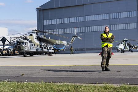OSTRAVA, CZECH REPUBLIC - SEPTEMBER 22: Man stands on a runway during airshow session NATO Days with Czech military Mil Mi-171Sh helicopter in background on September 22, 2012 in Ostrava, Czech republic.のeditorial素材