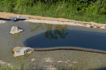 Natural swimming pond purifying water without chemicals through filters and plantsの写真素材
