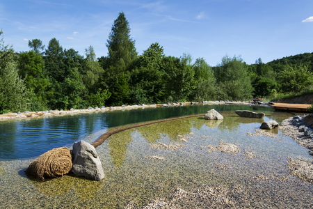 Natural swimming pond purifying water without chemicals through filters and plantsの写真素材