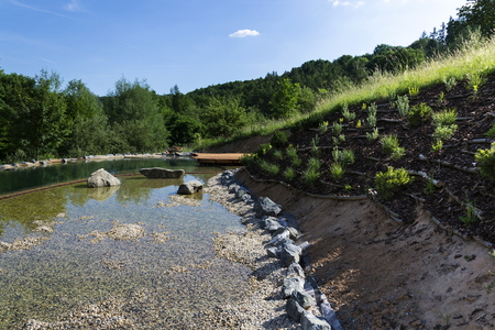 Natural swimming pond purifying water without chemicals through filters and plantsの写真素材