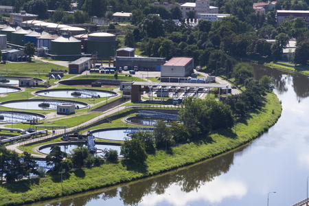 Aerial view of river meandering around sewage water treatment plantの写真素材