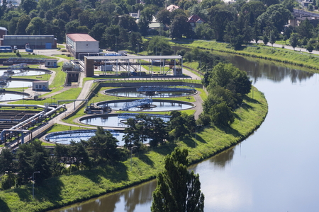 Aerial view of river meandering around sewage water treatment plantの写真素材