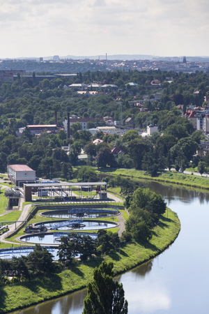 Aerial view of river meandering around sewage water treatment plantの写真素材