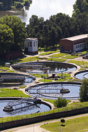 Men checking water storage tanks at sewage treatment plantの写真素材