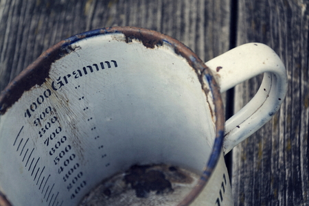 Old vintage metallic cup for 1000 grams on wooden backgroundの写真素材