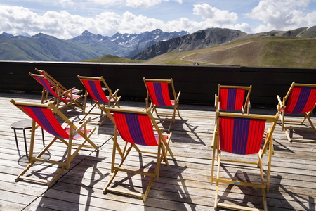 Colorful empy deckchairs on terrace with Italian Alps mountains viewの写真素材