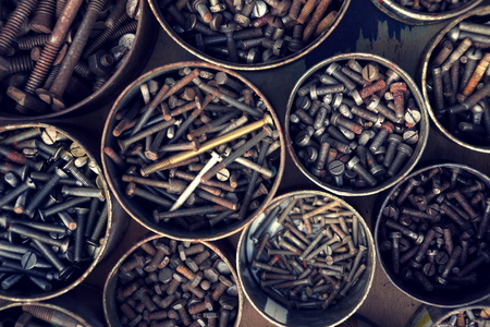 Filtered screws and bolts in tin can on wooden backgroundの写真素材