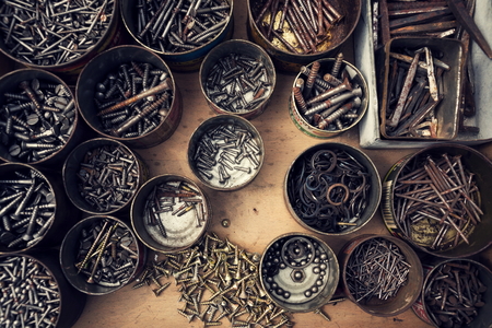 Filtered screws and bolts in tin can on wooden backgroundの写真素材