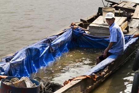 MY THO, VIETNAM - FEBRUARY 14: Fisherman sells fish on boat on February 14, 2012 in My Tho, Vietnam.のeditorial素材