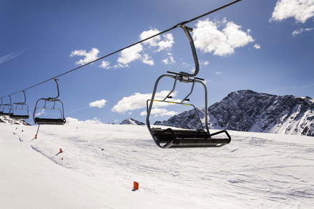 Empty ski chair lift on sunny day in Alps, Austria の写真素材