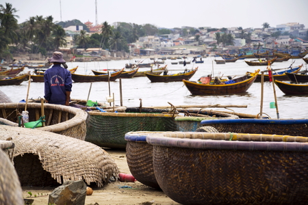 MUI NE, VIETNAM - FEBRUARY 7: Fishermen with colorful fishing boats on February 7, 2012 in Mui Ne, Vietnam.のeditorial素材
