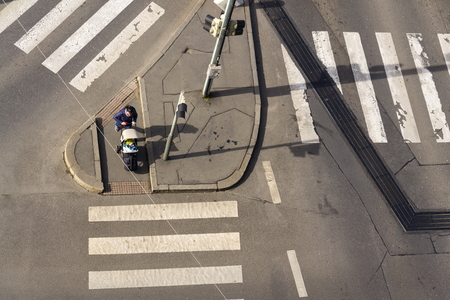 PRAGUE, CZECH REPUBLIC - MARCH 3: Bird's eye view of woman with kid in baby carriage waiting on intersection crossing for free crosswalk on March 3, 2017 in Prague, Czech republic.のeditorial素材