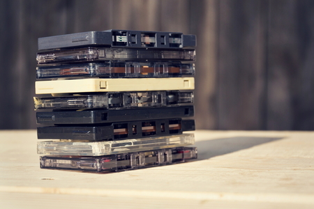 Filtered retro compact cassette audio magnetic tapes on wooden backgroundの写真素材