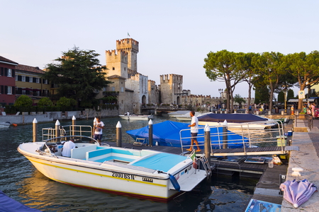SIRMIONE, ITALY - JULY 30: Boats floating in front of Scaliger Castle on 30 July 2016 in Sirmione, Italy.のeditorial素材
