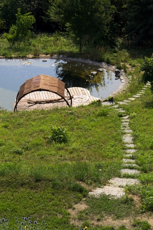 Wooden pier at natural swimming pond purifying water plantsの写真素材