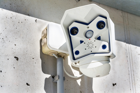 Dual lens modern security camera attached to wallの写真素材