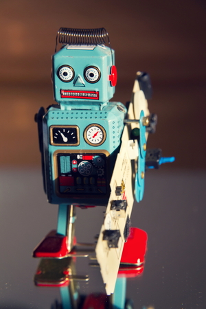 Tin toy robot carries computer circuit board, artificial intelligence conceptの写真素材